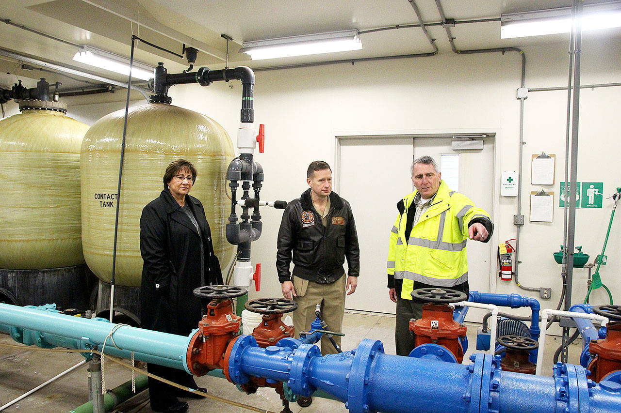 Coupeville Mayor Molly Hughes and Naval Air Station Whidbey Island base commander Capt. Matt Arny, center, listen as town Utility Superintendent Joe Grogan explains how water is currently treated and how that will work with the new filtration system. The Navy is paying for a new water treatment plant to remove toxic chemicals called PFAS. Photo by Laura Guido/Whidbey News-Times
