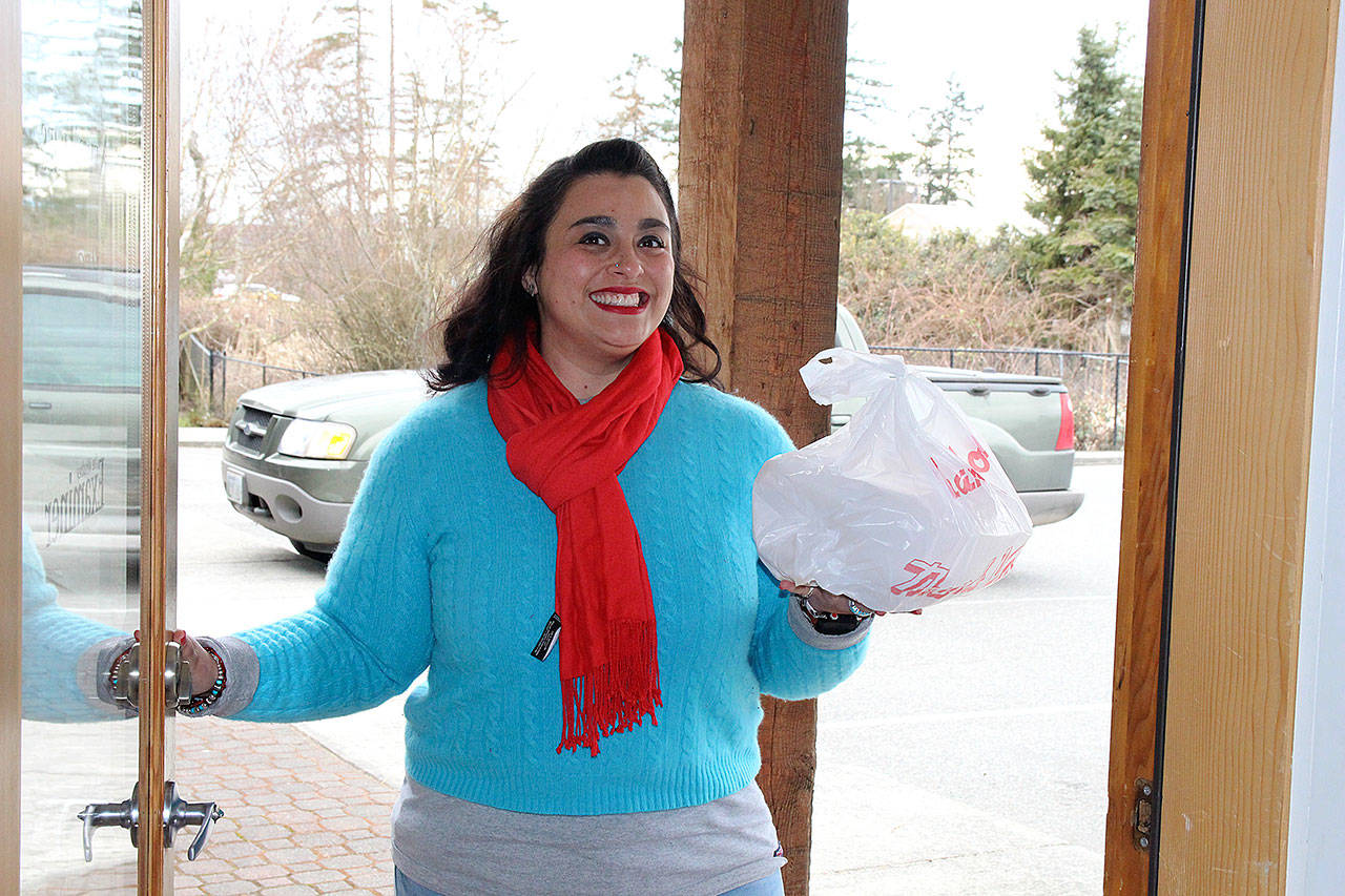 Crystal Aguilar, owner and founder of Whidbey Waiter, makes a delivery at a Coupeville office. Her business also delivers groceries, flowers, takes trash to the dump and makes Costco runs for its customers. Photo by Laura Guido/Whidbey News Group