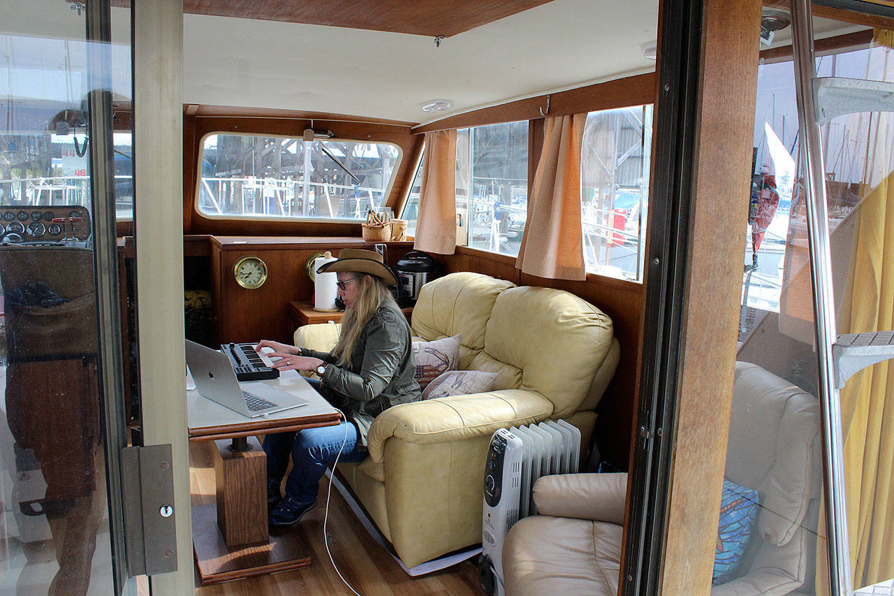 Holly Chadwick plays her electronic piano aboard her boat, Rubicon, where she plans to live at Oak Harbor Marina after selling her family home. (Photo by Patricia Guthrie/Whidbey News Group)