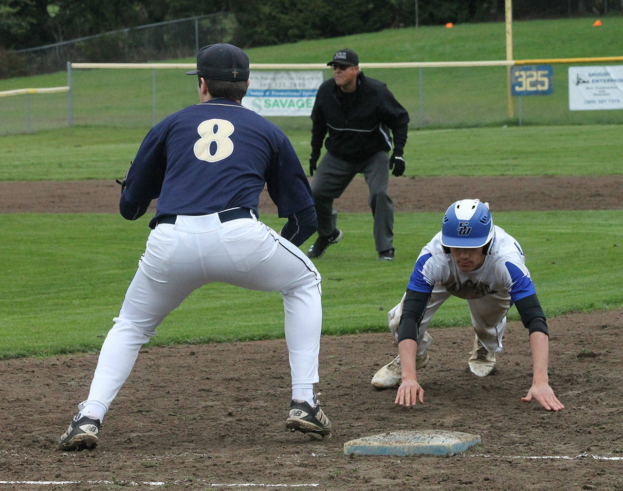 South Whidbey’s Alex Black dives safely back into first base. (Photo by Jim Waller/South Whidbey Record)