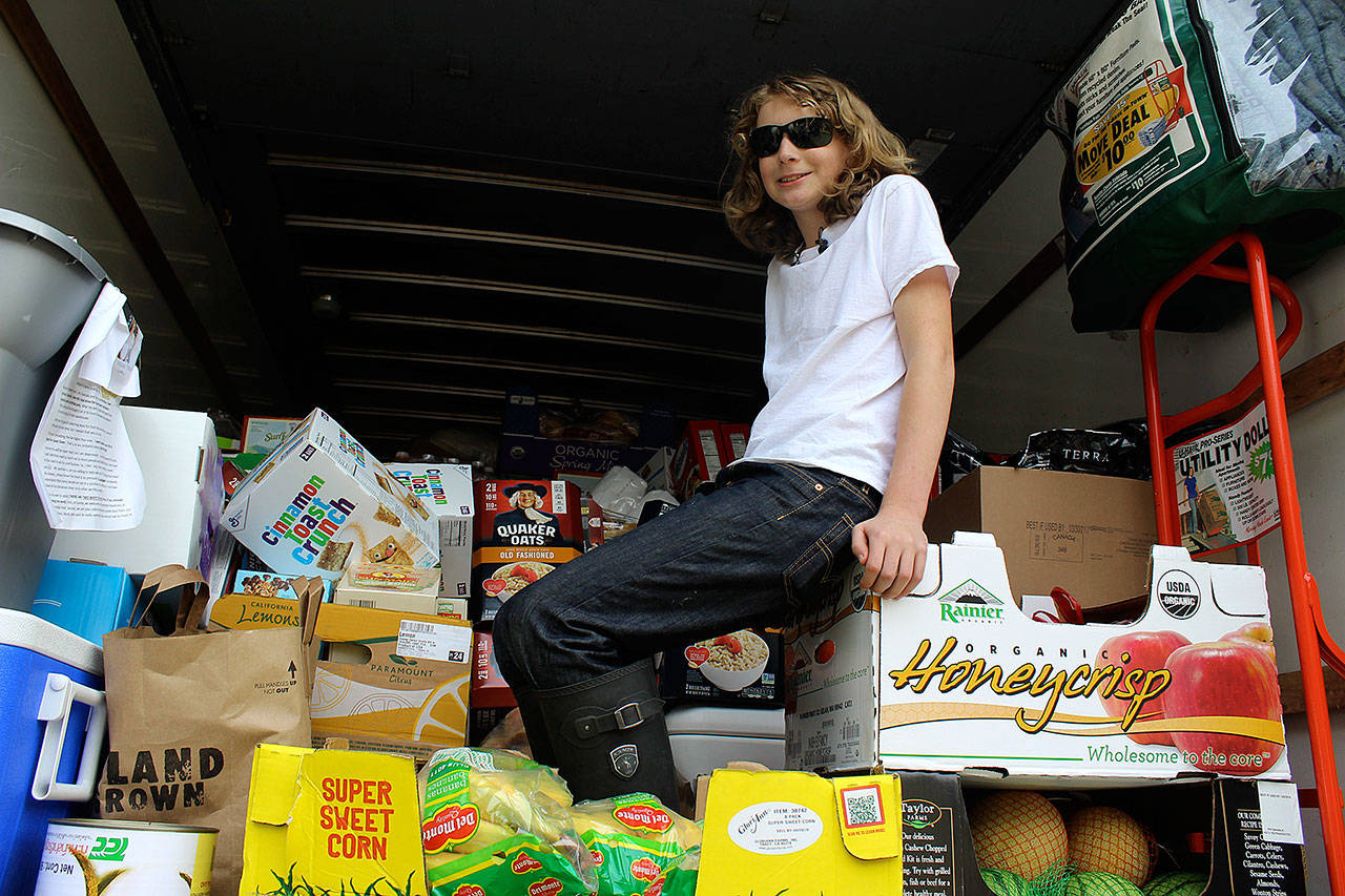 Spencer Jonas sits atop more than four tons of food he collected for his annual birthday food drive for Good Cheer Food Bank. (Photo by Patricia Guthrie/Whidbey News Group)