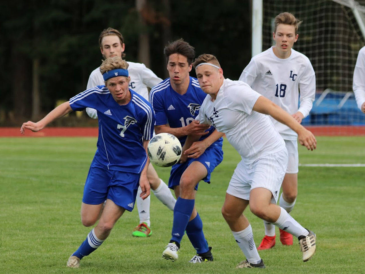 South Whidbey’s Eli Waldron (7) and Michael Lux (10) battle Lynden Christian for possession in Monday’s district tournament win.(Photo by Matt Simms)