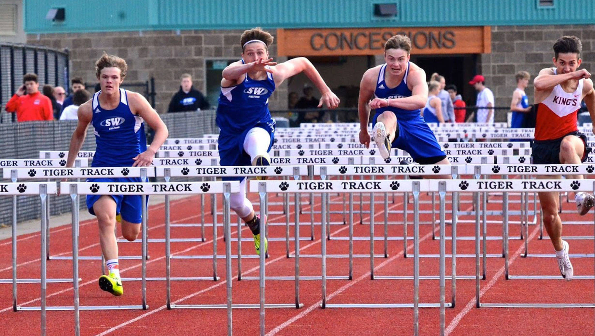 Cody Eager, left, Kole Nelson and Bodie Hezel run the 110 hurdles in the league meet Thursday. Hezel finished first, Nelson second and Eager fourth. (Photo by Karen Swegler)