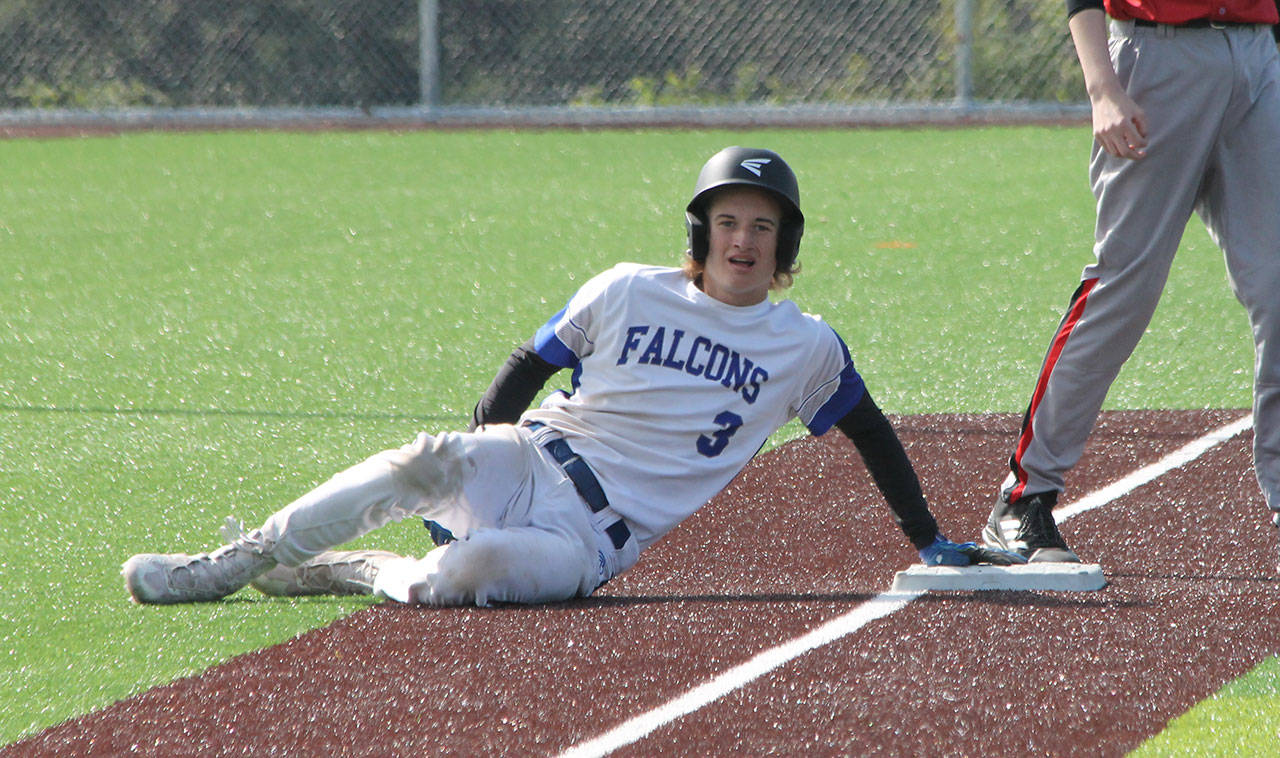 Kody Newman hangs on after sliding safely into third base.(Photo by Jim Waller/South Whidbey Record)