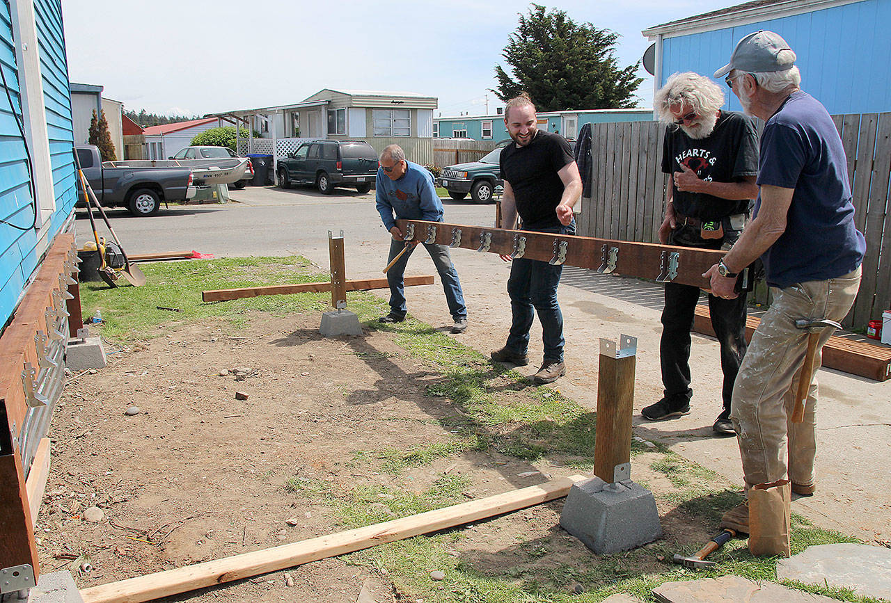Volunteers from Central Whidbey Hearts Hammers work on building a deck. From left to right are Chuck Hathaway, Devin Short, house captain Gary Wray and Dave Park. (Photo by Maria Matson/ South Whidbey Record)