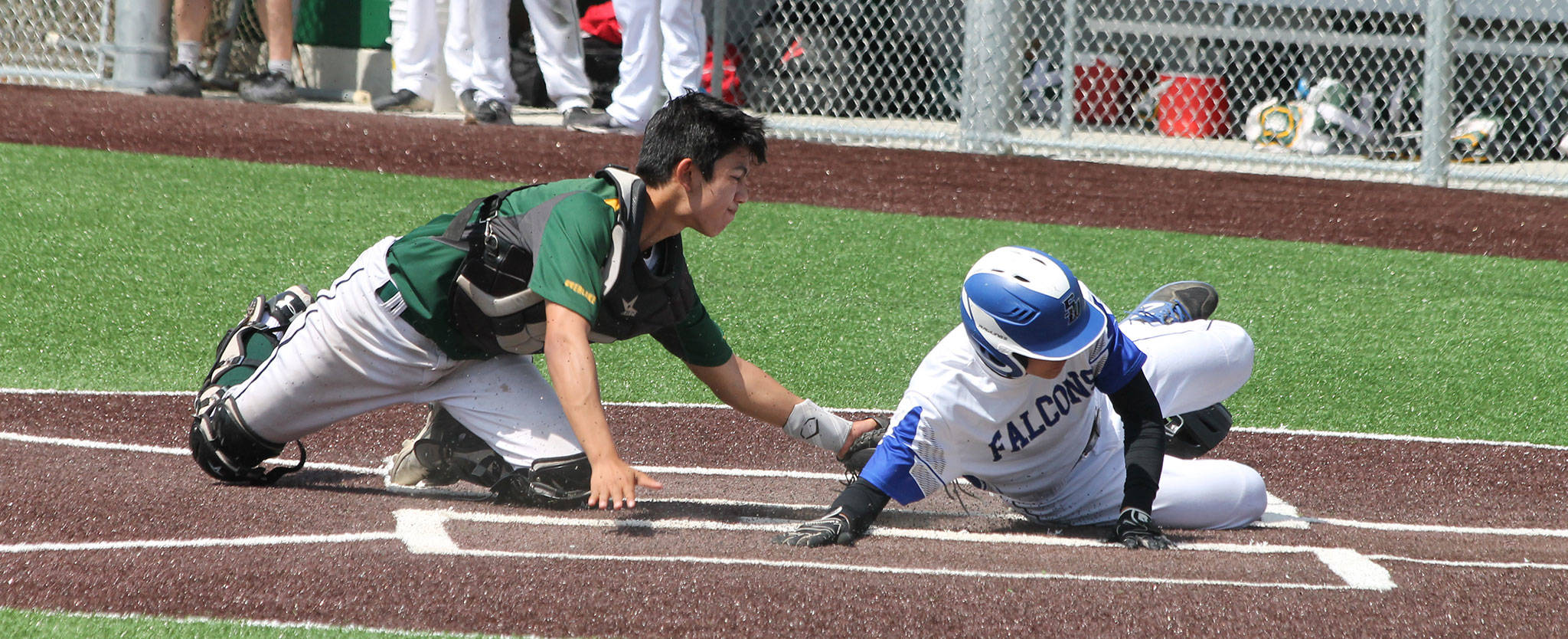 South Whidbey’s Nick Black, right, slides safely across home on a squeeze bunt.(Photo by Jim Waller/South Whidbey Record)