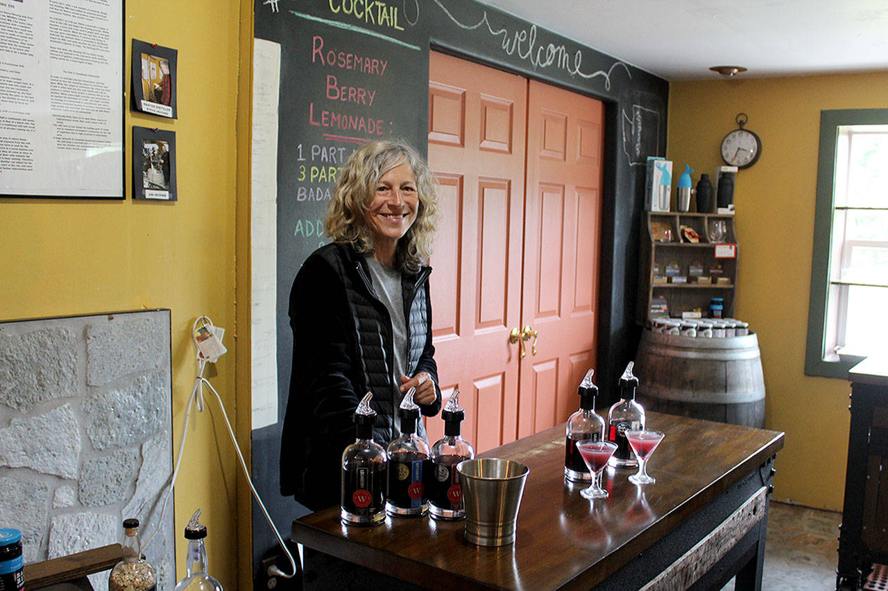 Whidbey Island Distillery spirits guide Michelle Molner pours two speciality craft cocktails for customers. The company is releasing Lavender Infused Loganberry Liqueur as part of its Savor Spring offerings. (Photo by Patricia Guthrie/Whidbey News Group)
