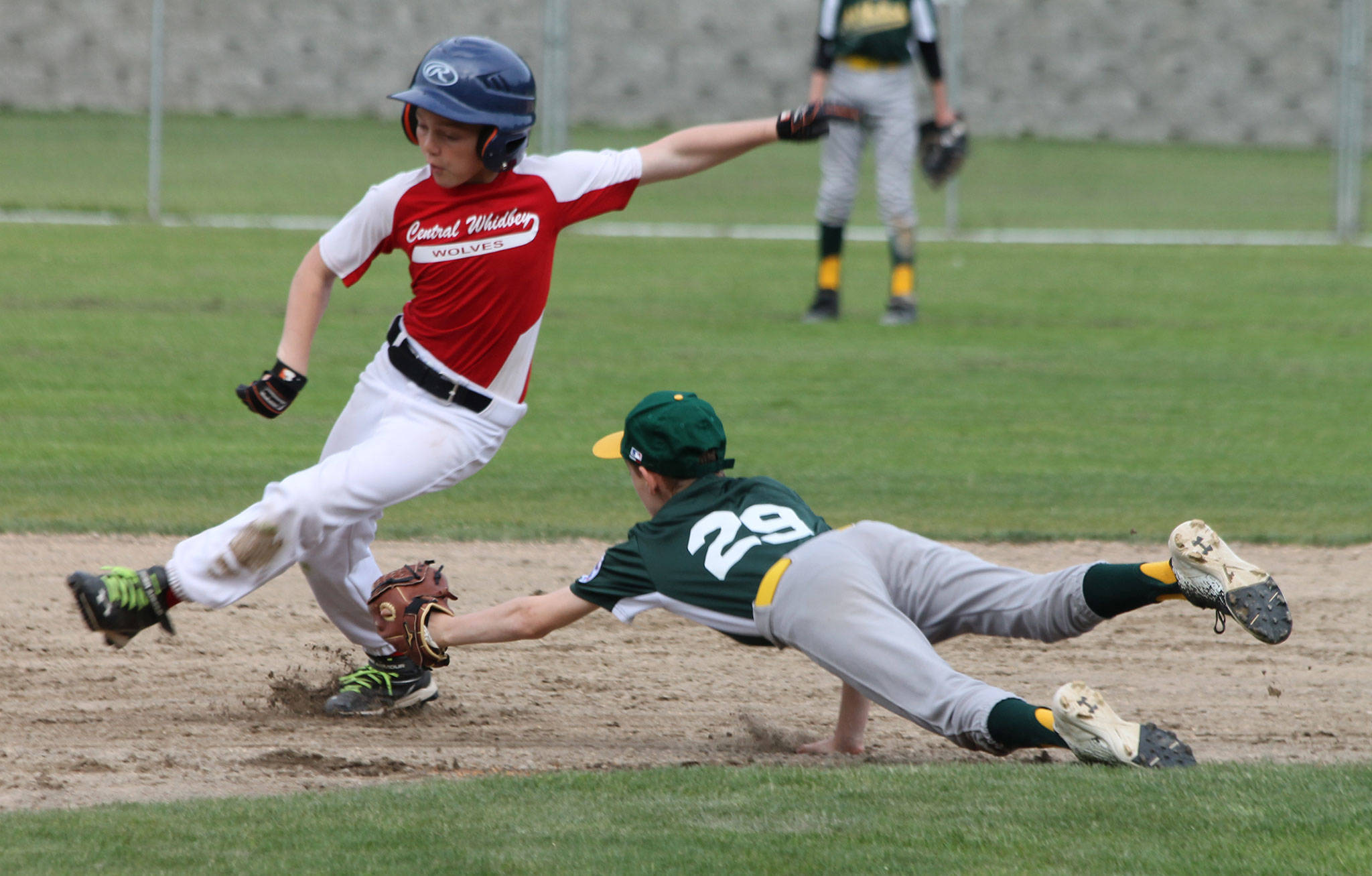 South Whidbey shortstop Jaden Adragna (29) — donning traditional high-stirrup socks — dives in an attempt to tag a Central Whidbey base runner Wednesday. (Photo by Jim Waller/South Whidbey Record)
