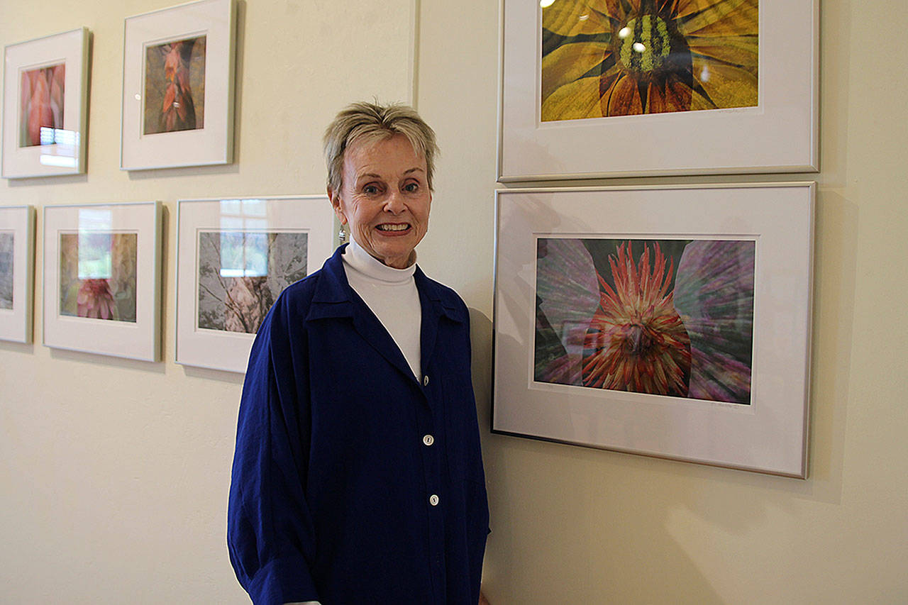 Marie Plakos stands with her work at the Bayview Corner’s Front Room Gallery. Her photos explore “the feminine in nature,” she said. Photo by Maria Matson/Whidbey News Group