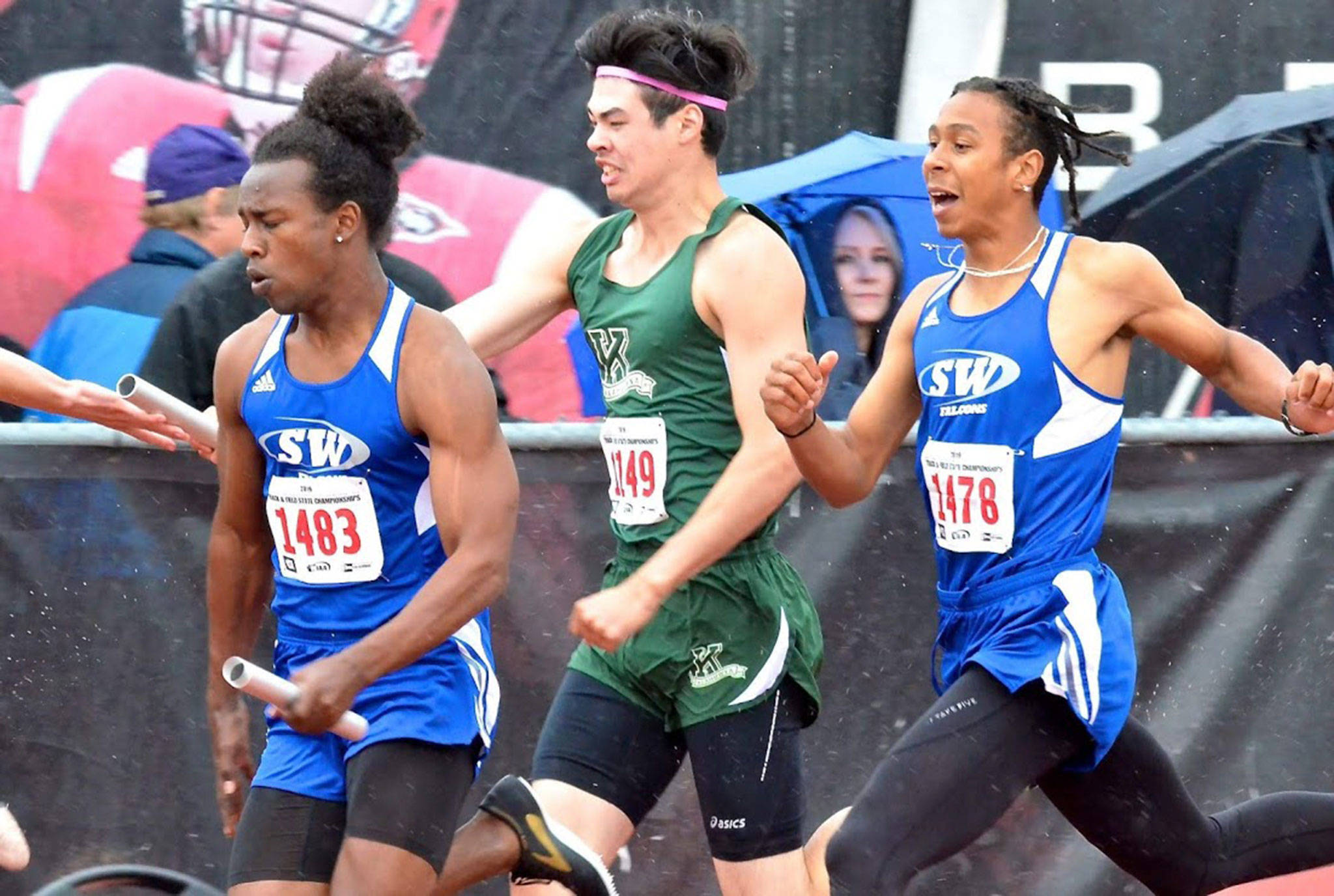 Matthew Simmons, left, takes off after receiving the baton from Issiah Gonzales.(Photo by Karen Swegler)