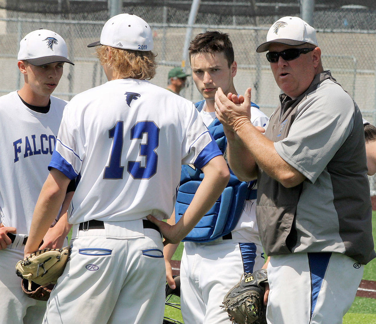 South Whidbey baseball coach Tom Fallon, right, meets on the mound with pitcher Ethan Petty, left, third baseman Drew Fry (13) and catcher Dexter Jokinen. Fallon was named the conference’s Coach of the Year, Petty the Pitcher of the Year and Fry first-team, all-league. (Photo by Jim Waller/South Whidbey Record)