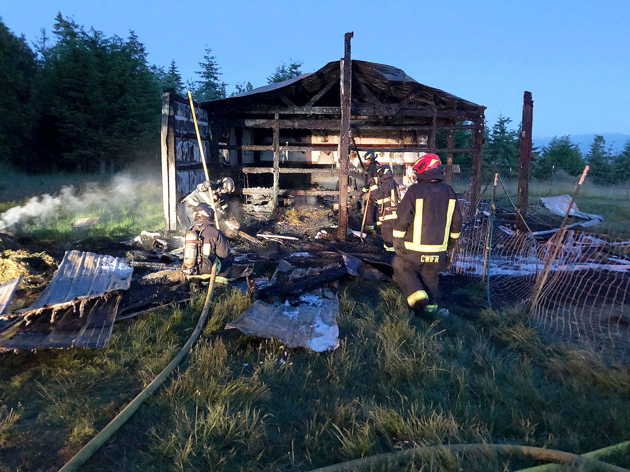 Central Whidbey Fire and Rescue firefighters work to extinguish a fire Tuesday morning at a barn in Greenbank. Photo provided