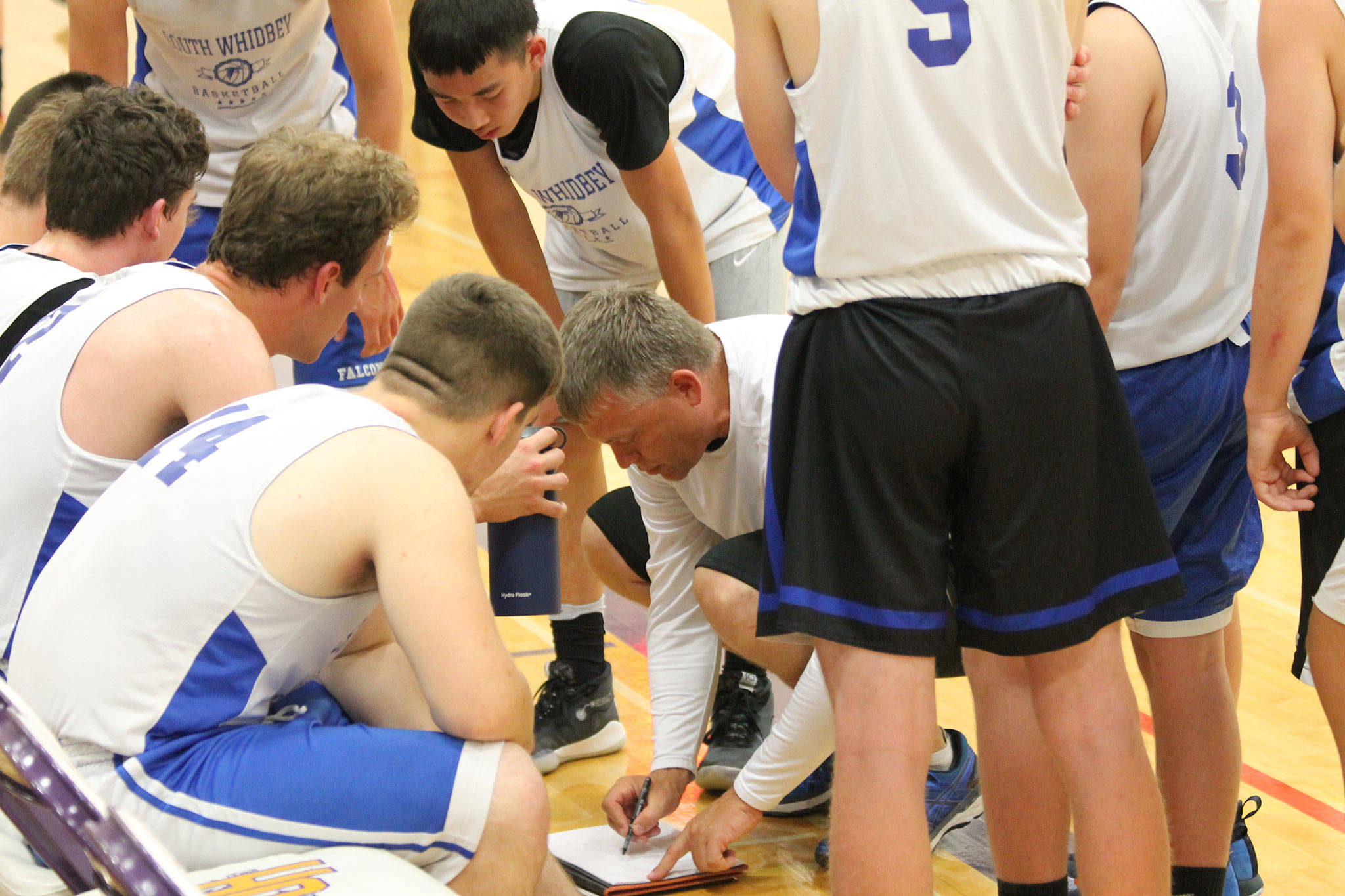 New boys basketball coach Greg Turcott draws up a play during a break at a scrimmage in Oak Harbor Wednesday. (Photo by Jim Waller/South Whidbey Record)