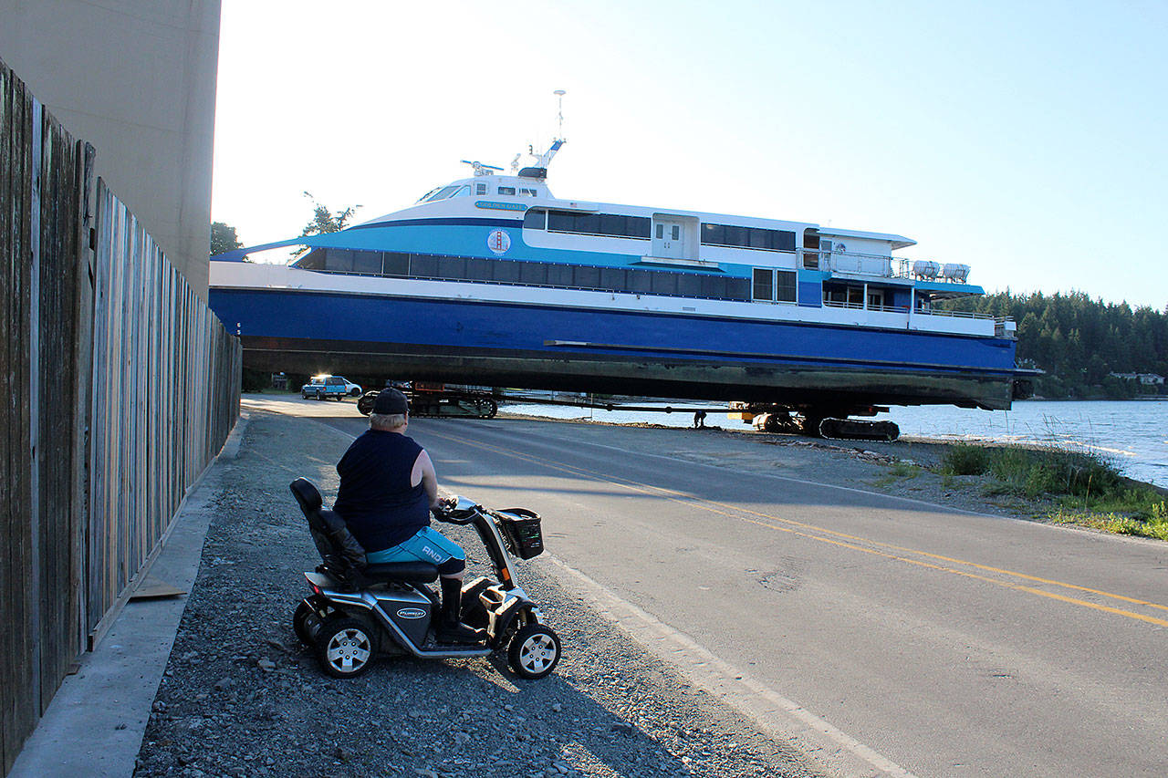 Jake Johnson watches as a San Francisco ferry moves slowly out of the water toward Nichols Brother Boat Builders at Holmes Harbor. The vessel is in for repairs, one of several the Freeland boatyard has worked on for Golden Gate Bridge fast ferries over the years. Photo by Patricia Guthrie/Whidbey News Group