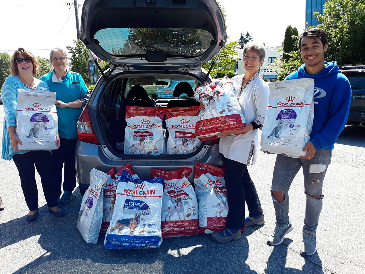 Good Cheer accepts a large donation of food June 24 in downtown Langley outside the Animal Hospital. From left to right: Good Cheer board member Kelly Turner-Gibson, Animal Hospital by the Sea Dr. Jean Dieden, Executive Director of Good Cheer Carol Squire and Good Cheer summer intern Kyle Kaltenbach. (Photo provided)