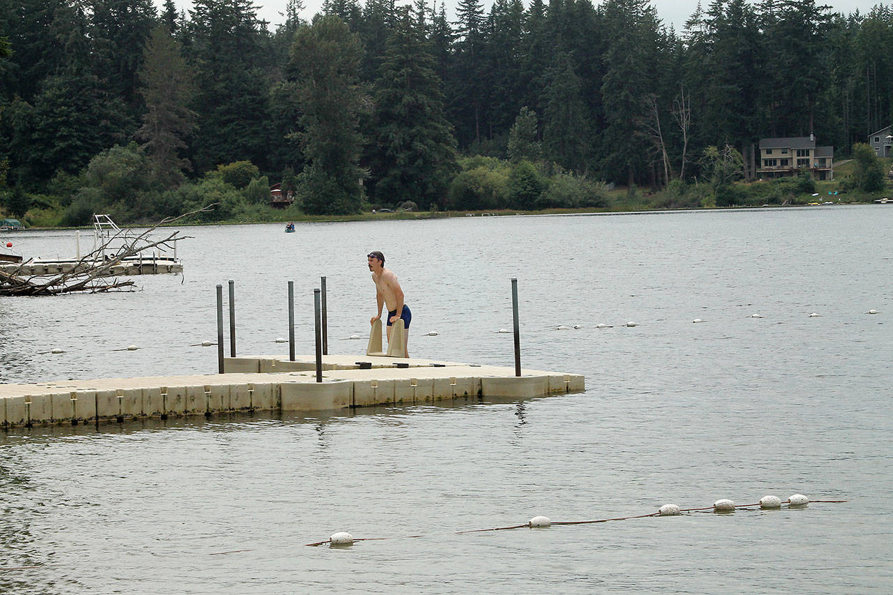 Photo by Jessie Stensland / South Whidbey Record                                Jack Baars pulls himself up on a float at Deer Lake after taking a swim earlier this month. He said the water was perfect.
