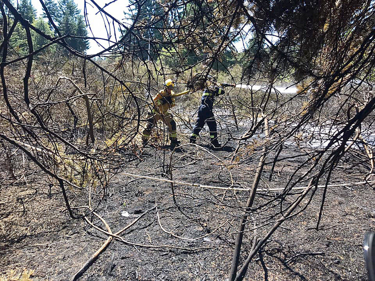 South Whidbey Fire/EMS firefighters extinguish a brush fire near Humphrey Road Friday afternoon. Photo provided                                South Whidbey Fire/EMS firefighters extinguish a brush fire near Humphrey Road Friday afternoon. Photo provided