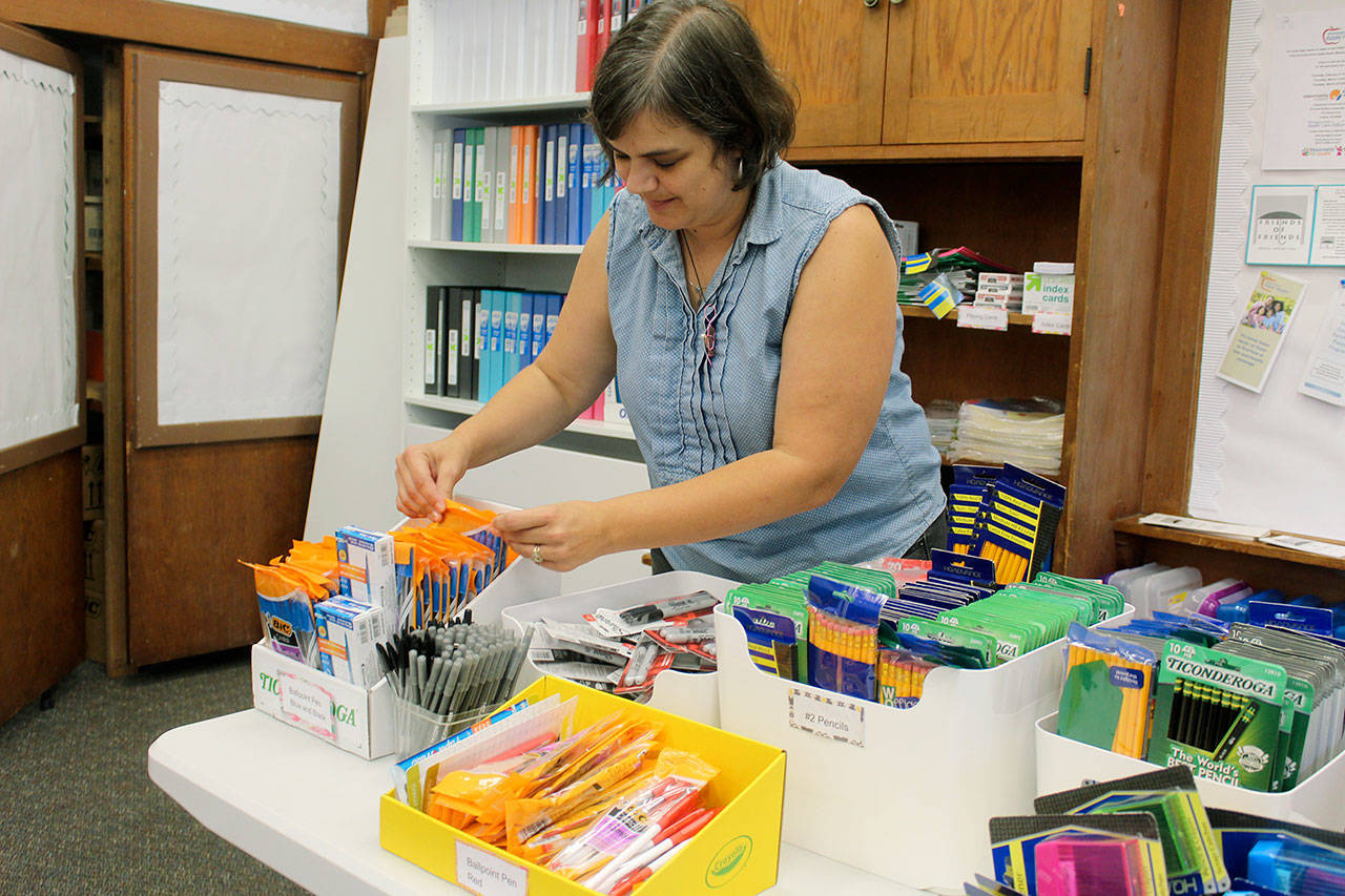 Cailyn Murray sorts through lots of school supplies at the Family Resource Center. (Photo by Wendy Leigh/South Whidbey Record)