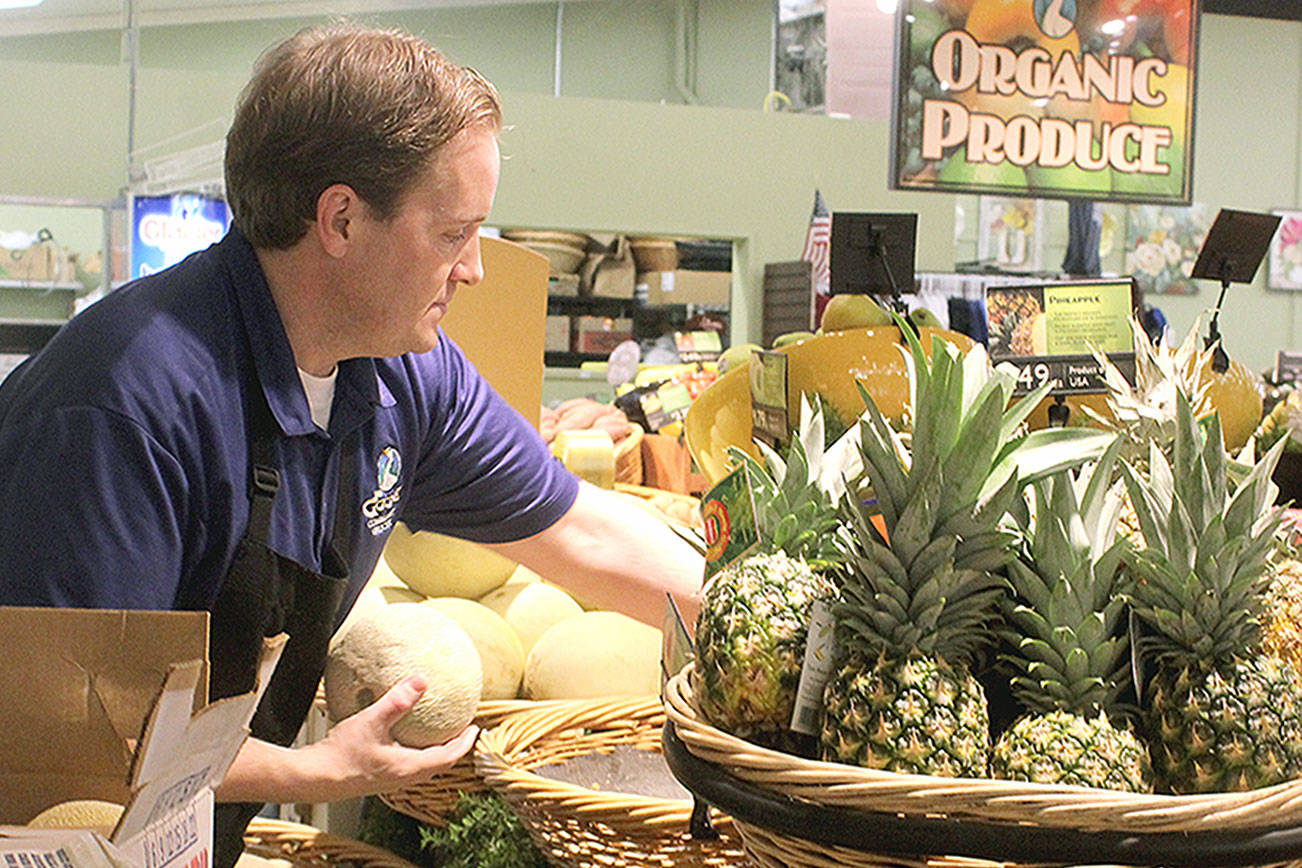 Employee Seth Haynie stocks organic produce at The Goose Community Grocer in Bayview