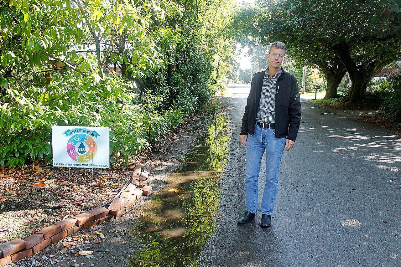 Photo by Jessie Stensland / Whidbey News-Times                                Jim Dobberfuhl stands near a puddle at the end of his driveway that becomes a small lake when it rains. He hopes storm water infrastructure will help.