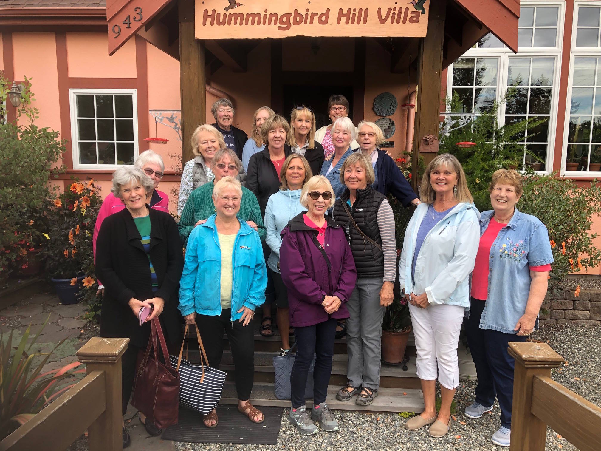 The members of the South Whidbey Garden Club pose for a photo on Annette Barca’s stairs and deck a our tour of The Hummingbird Hill Garden in Greenbank. Photo submitted