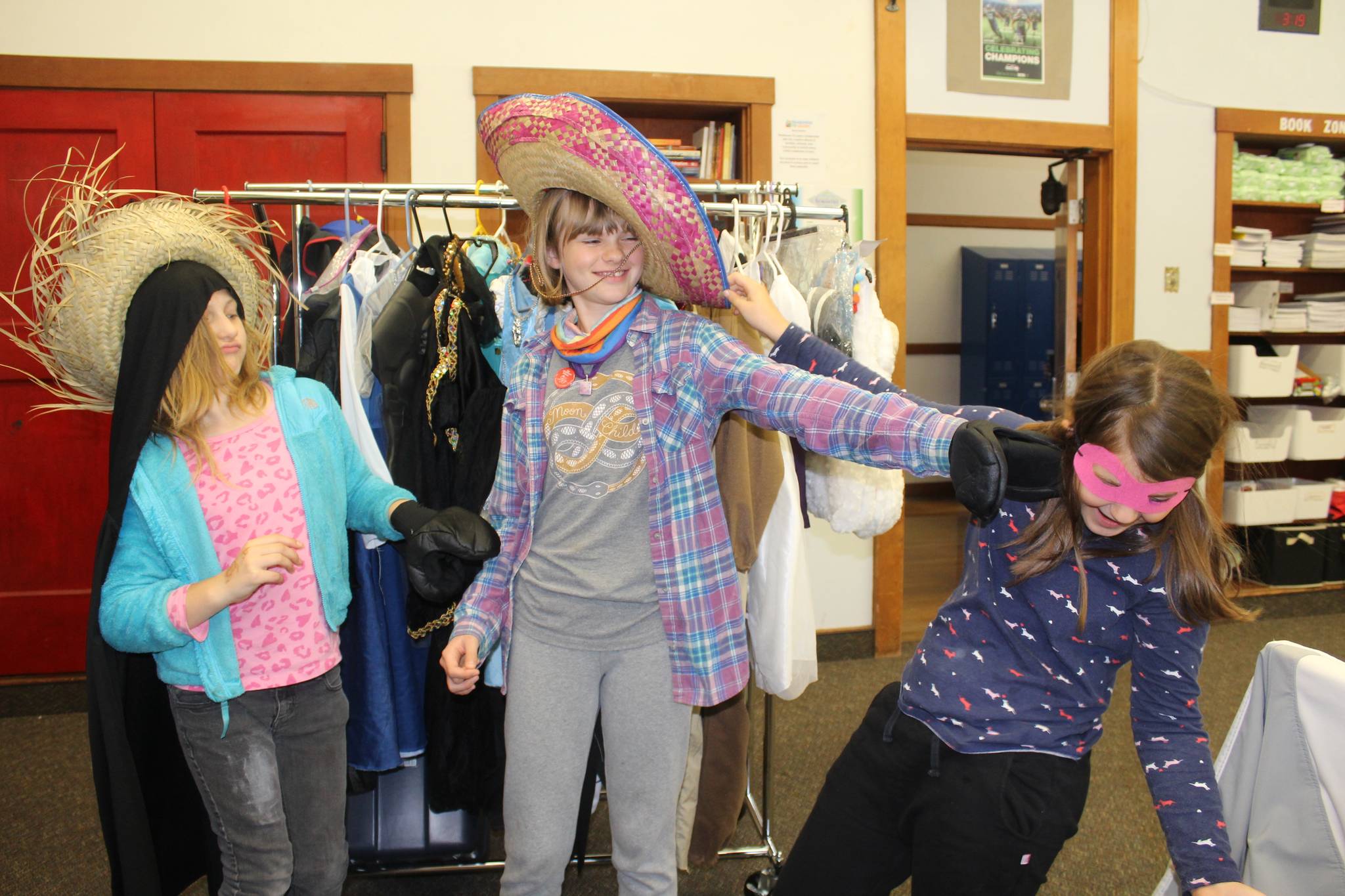 Maegan Donier, left, and sisters Ada and June Murray find matching hats and accessories at the costume swap taking place through Oct. 30 at Langley’s Family Resource Center. Photo by Wendy Leigh / South Whidbey Record
