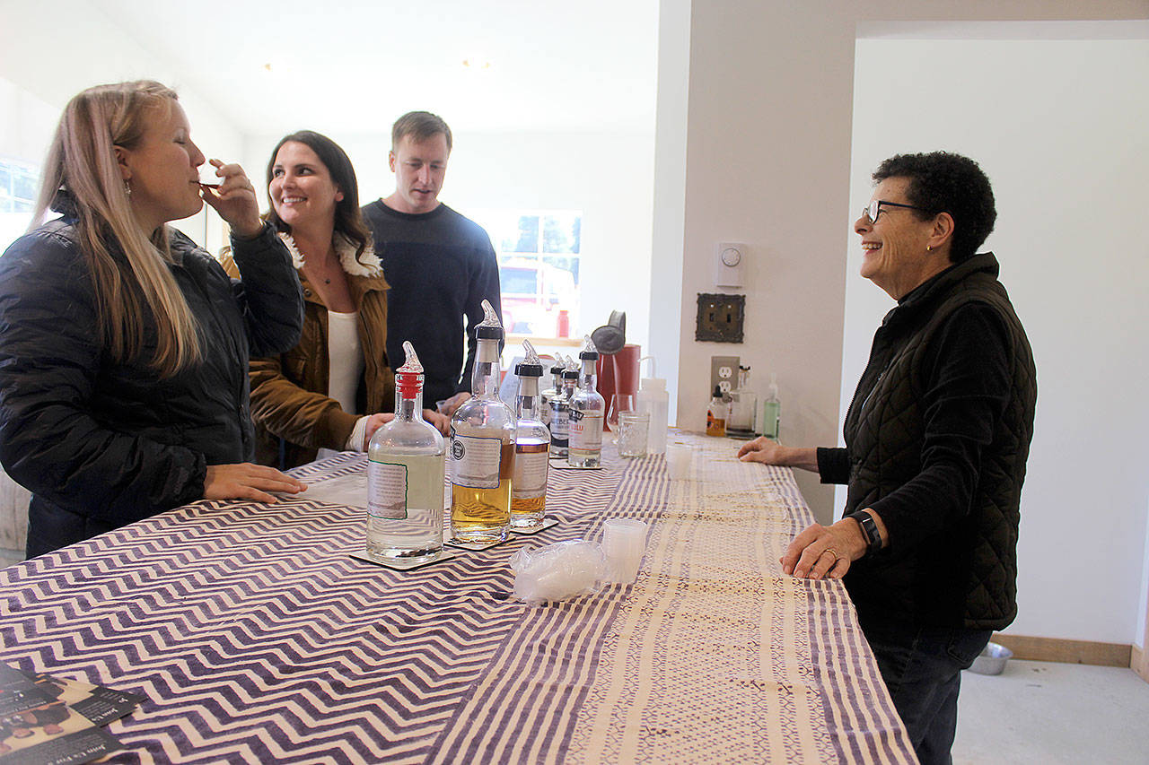 Kathy Stallman, co-owner of Mutiny Bay Distillers, gives visitors a tasting of the company’s hand-crafted small-batch whiskeys. Photo by Wendy Leigh / South Whidbey Record