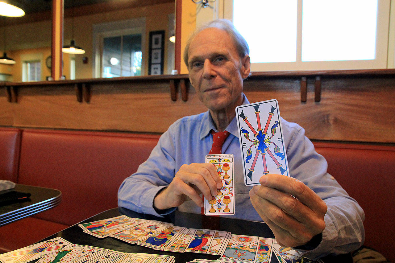Photo by Kira Erickson                                Gerry Reed holds up the third card in his tarot deck, a reissue of a deck from 1781.