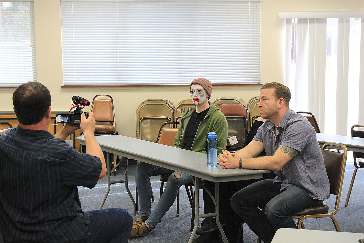 Jared Maybury, left, and Patrick Cain manage to maintain straight faces while filming last Sunday in Oak Harbor.