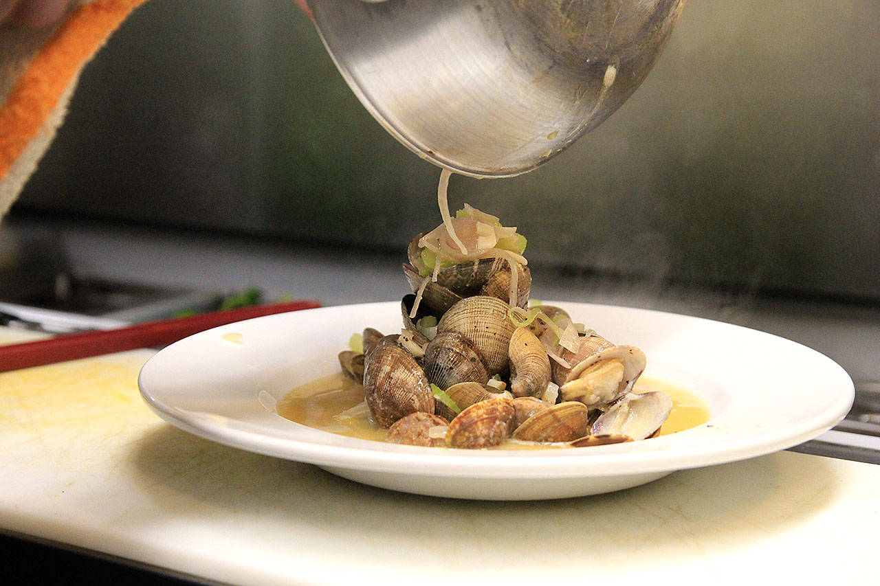 Chef Damien Cortez plates manila clams with wild board sausage, lemon, garlic, shallots, cooked in Rainier beer.