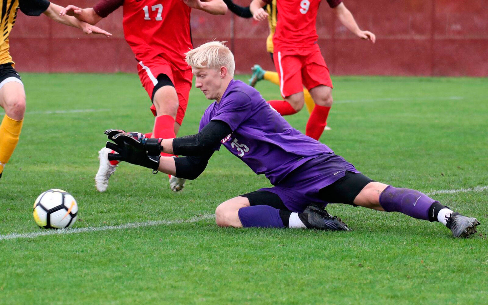 South Whidbey High School graduate Julian Inches records a save for the Linfield College soccer team this fall. (Photo courtesy of Linfield Athletics)
