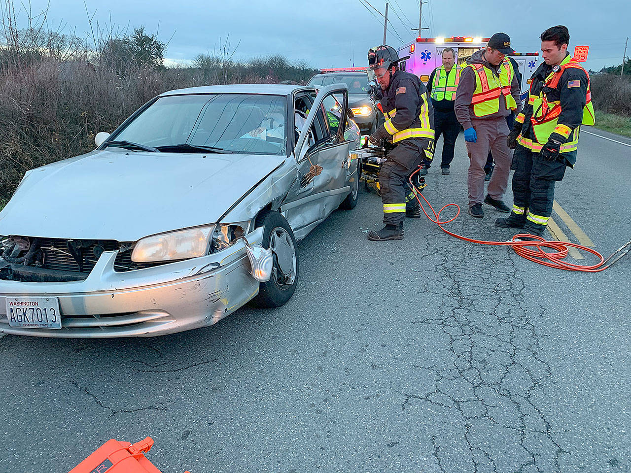 Apparatus Operator Ed Pratt, of Central Whidbey Island Fire and Rescue, uses a hydraulic rescue tool to remove a door from the heavily damaged door of a sedan involved in a hit-and-run accident Thursday. Photo provided by Central Whidbey Island Fire and Rescue