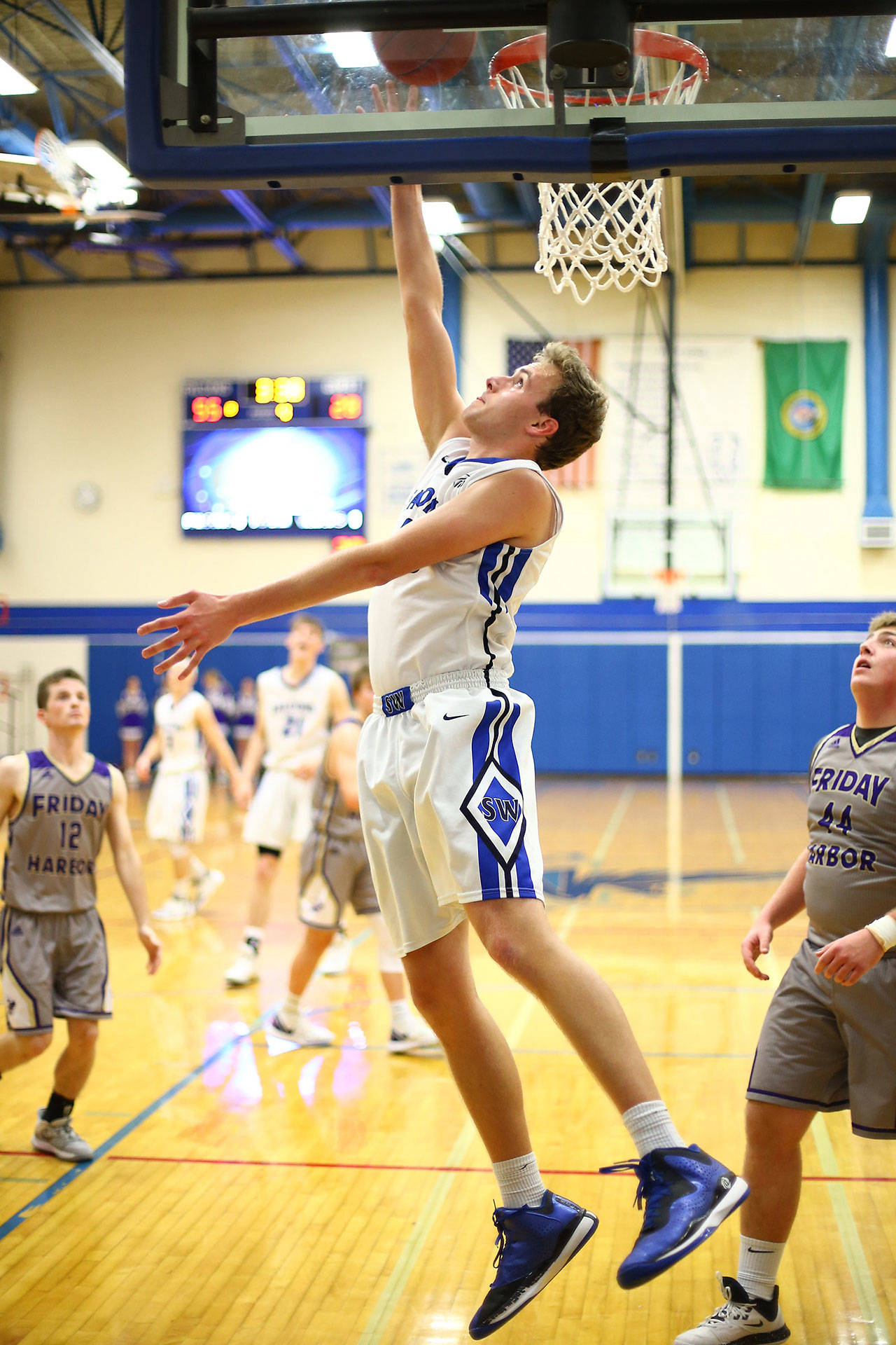 Levi Buck shoots a reverse lay-up for the Falcons. (Photo by John Fisken)