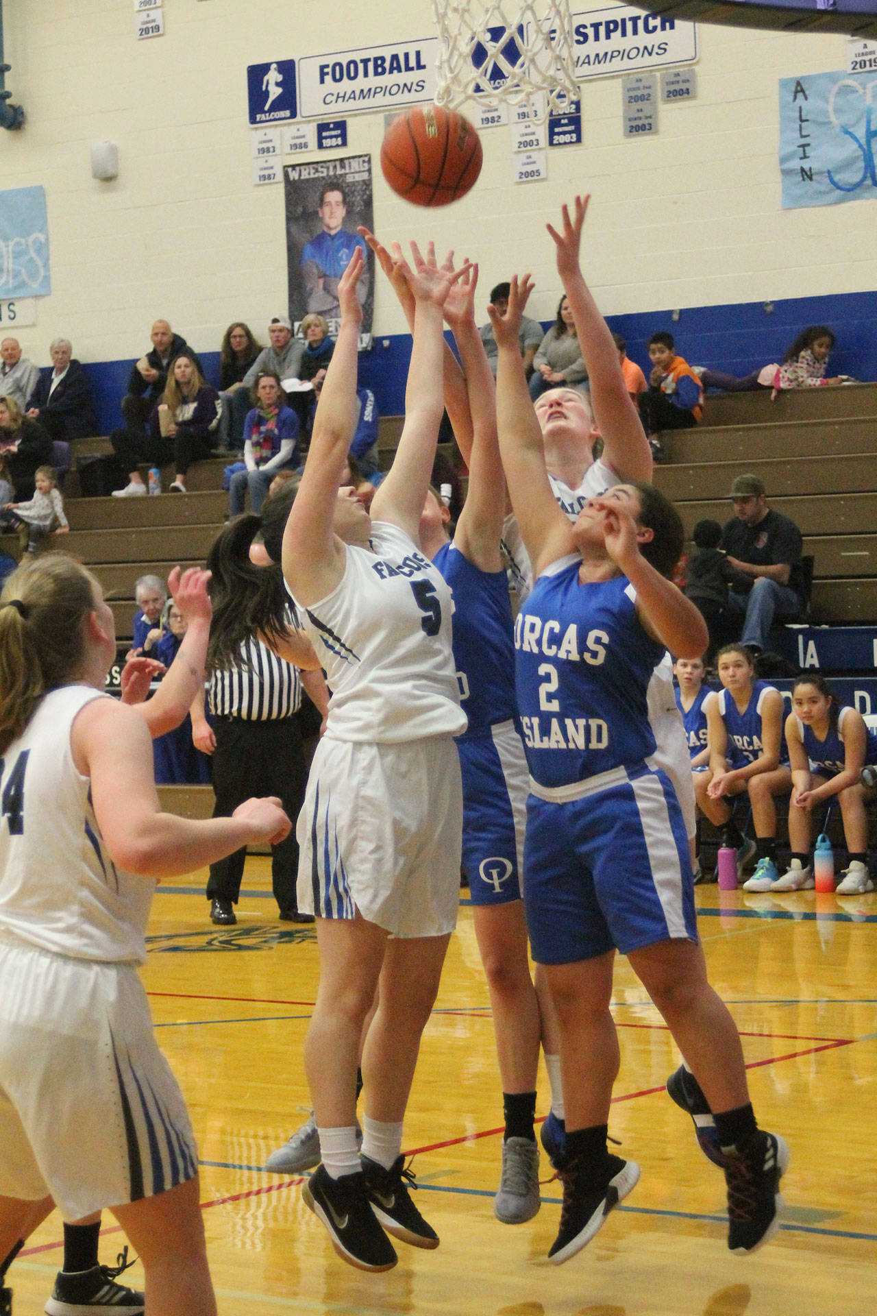 Madi Knauer (5) and Isabelle Wood leap for a rebound.(Photo by Jim Waller/South Whidbey Record)