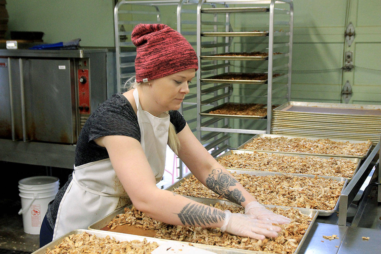 Photo by Kira Erickson/South Whidbey Record                                Kitchen Manager Hannah Hunsberger spreads the granola onto baking sheets and prepares it for baking Jan. 9.