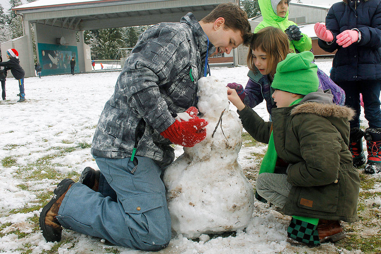 Fourth grade teacher James Nelson builds a snowperson with his students at South Whidbey Elementary School.