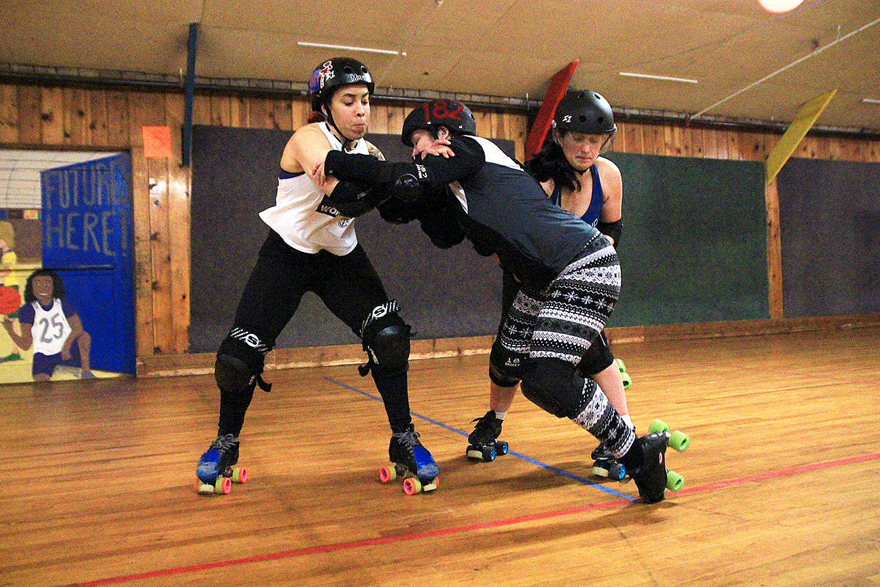 Photo by Laura Guido/Whidbey News-Times                                From left, Loanna Freakin Rican Delvillar, Nichole Malice in Derbyland Burton and Nicole Kay Oss ONeill clash in a blocking drill at the Whidbey Island Roller Girls Thursday night practice.