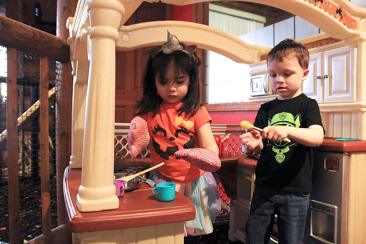 Photo by Laura Guido/Whidbey News Group                                Kara Pelzel, 3, and Ethan Boswell, 4, toil away in the kitchen space at Oak Harbor Playtown.