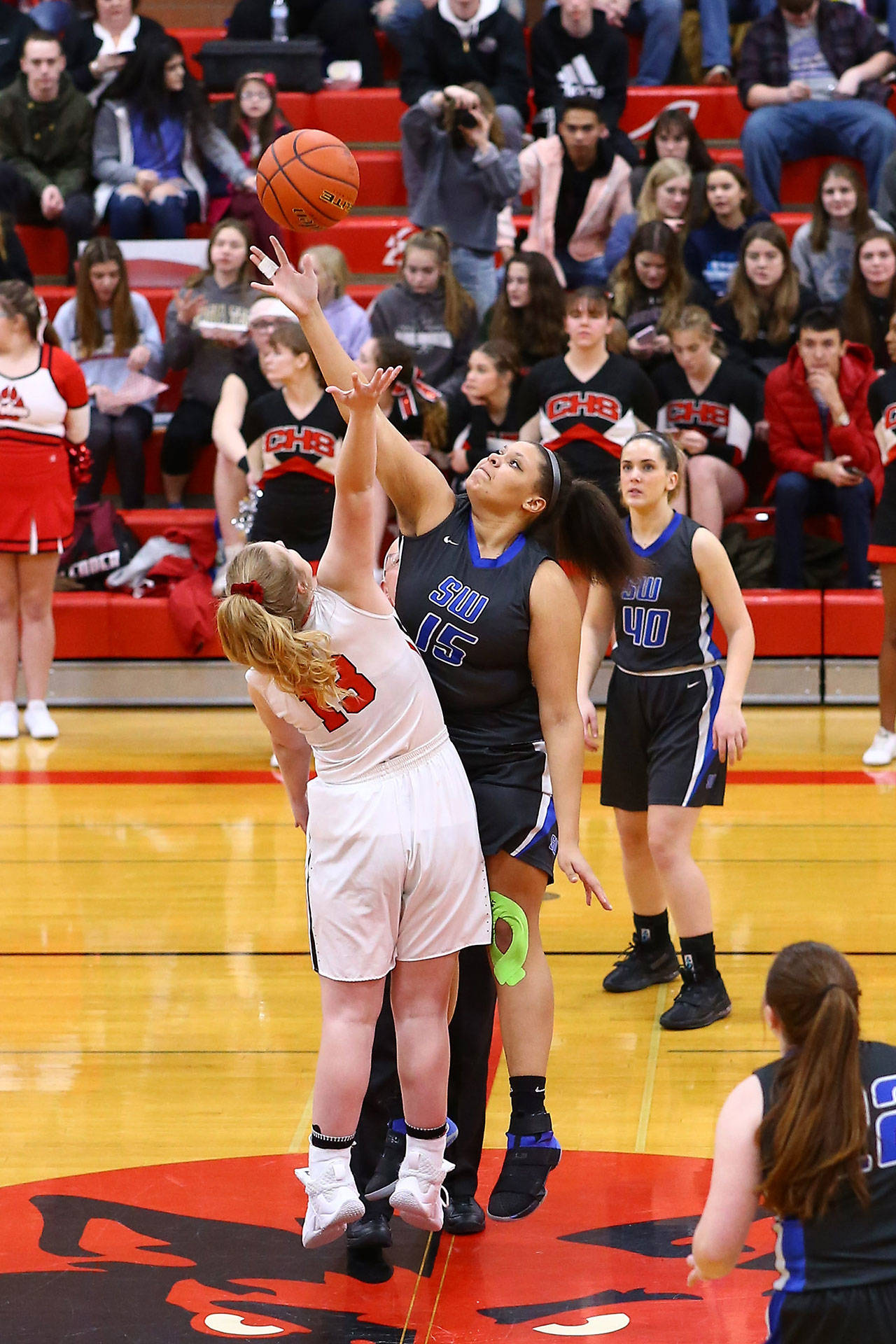 South Whidbey’s Arianna Briggs, right, out jumps Coupeville’s Hannah Davidson on the opening tip.(Photo by John Fisken)