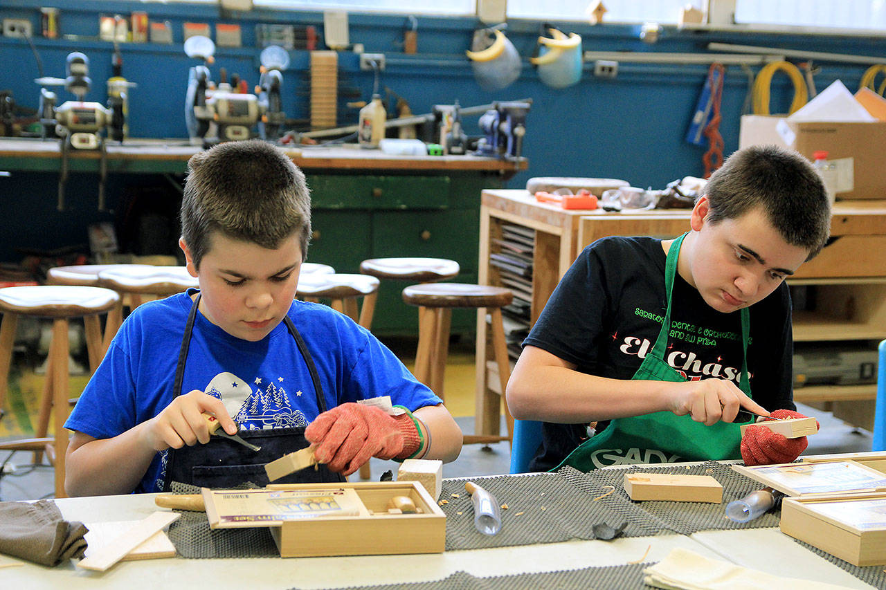 Photo by Kira Erickson/Whidbey News Group                                Seventh graders Zachary Craven and Sean Walker practice whittling a block of wood.