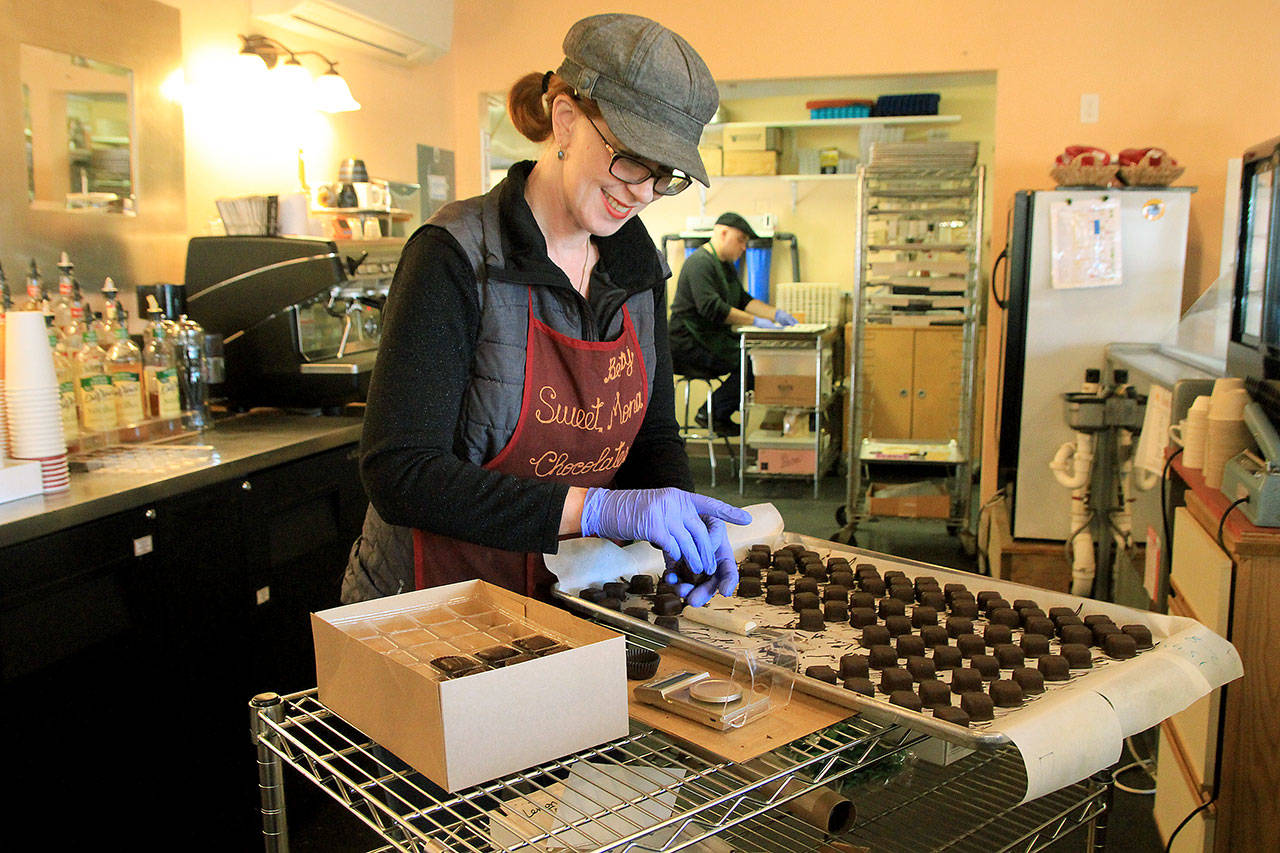 Photo by Kira Erickson/Whidbey News Group                                Chocolate maker Betsy Harvey weighs dark chocolate at Sweet Mona’s. The chocolate shop provides sweet treats for some of the stops along the self-guided Red Wine and Chocolate Tour.