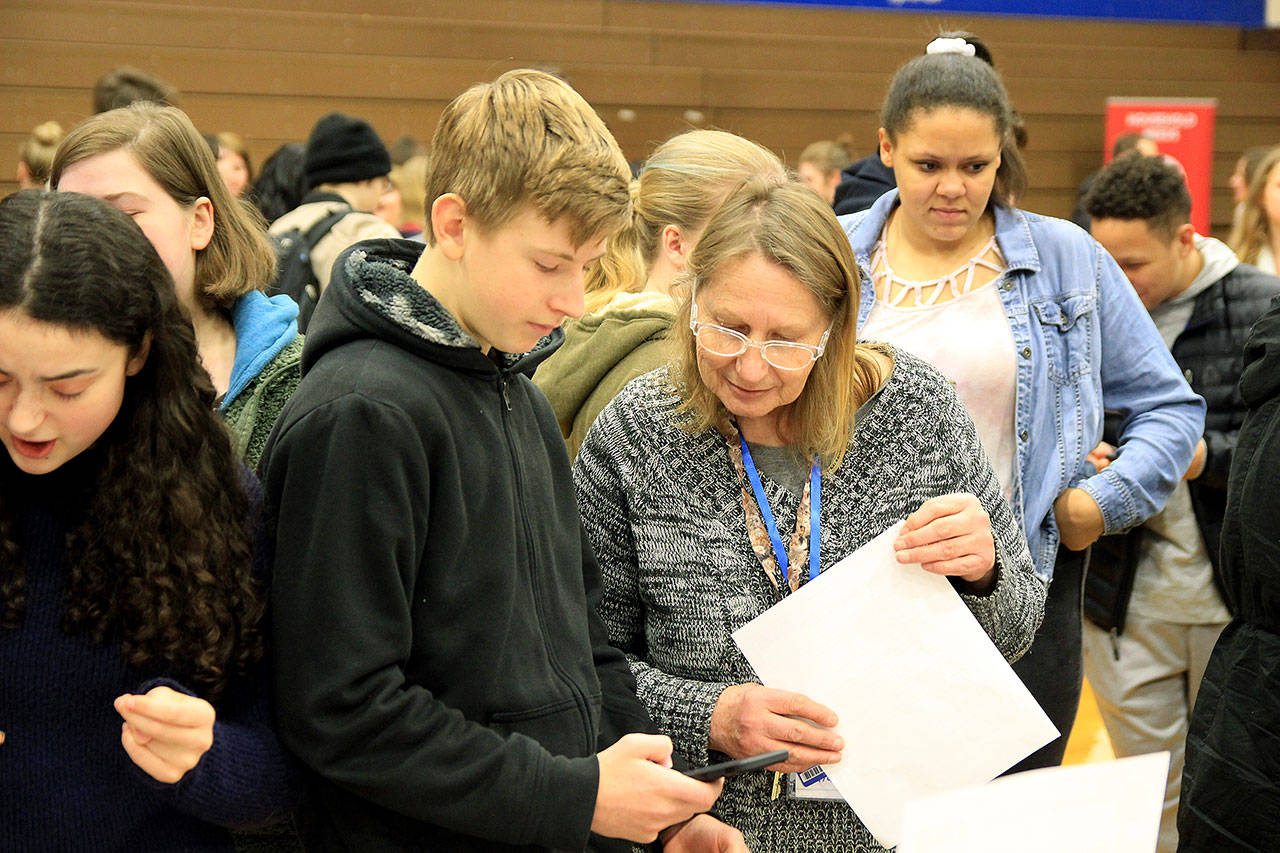 Photos by Kira Erickson/Whidbey News Group                                Volunteer Lydia Johnson helps freshman Slater Canright make a purchase during the simulation.