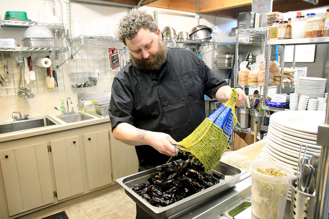 Photo by Kira Erickson/Whidbey News Group                                The Cove chef and co-owner Damien Cortez sifts through a new shipment of mussels from Penn Cove Shellfish.