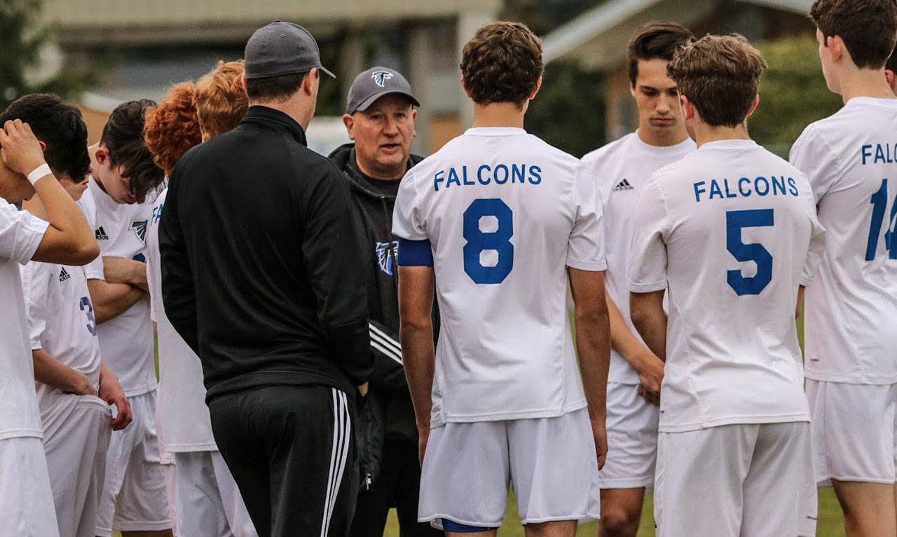 Coach Emerson Robbins, facing camera, talks to his South Whidbey team last spring. (Photo by Matt Simms)