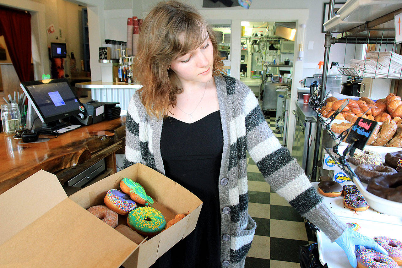 (Photos by Kira Erickson/Whidbey News Group)                                Employee Rashelle Scriven selects doughnuts for the cafe’s new “blue glove” delivery service.