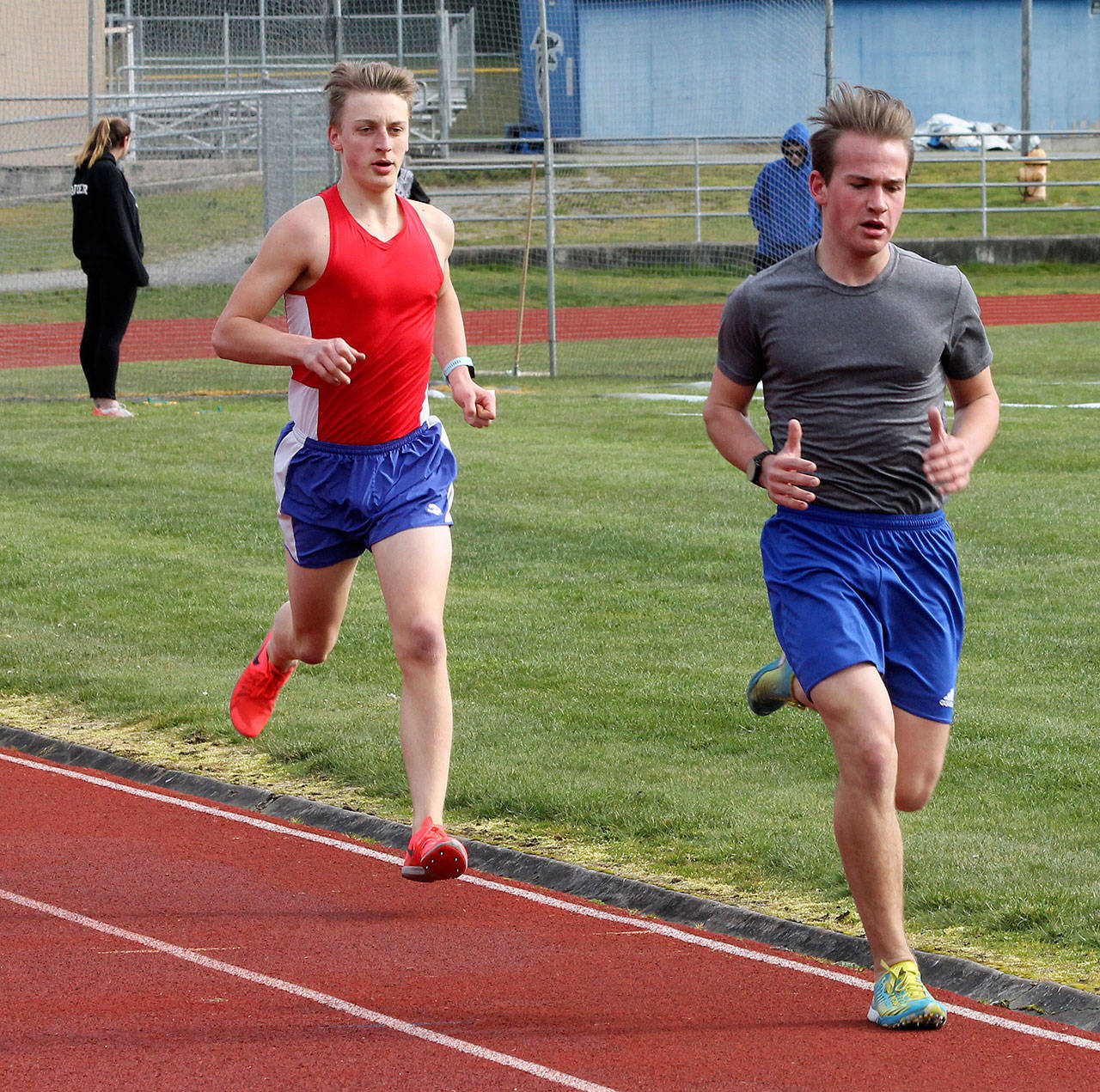 Cooper Ullmann, left, and Michael Harwell compete in the 1,600 Saturday. (Photo by Jim Waller/South Whidbey Record)