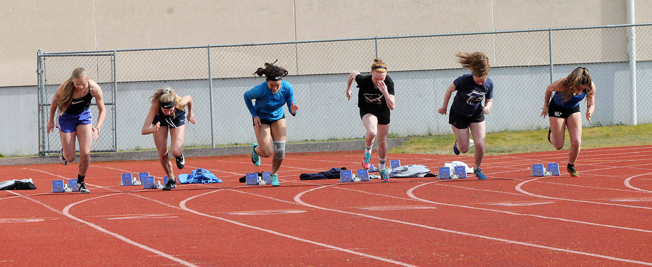 The Falcons shoot out of the blocks in the girls 100 meters. (Photo by Jim Waller/South Whidbey Record)