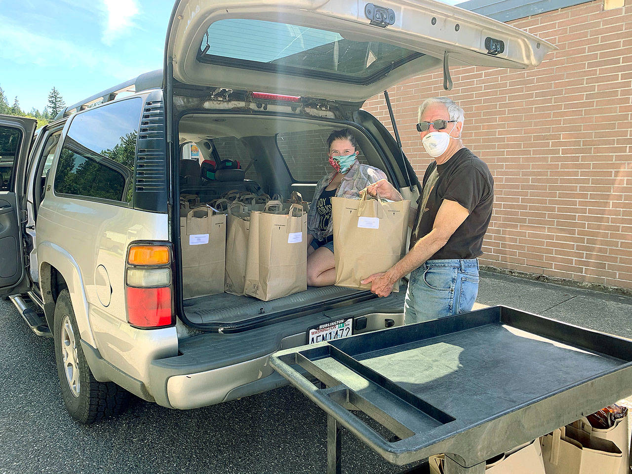 Photo provided                                WIN board member Ted Ravetz and delivery driver Kymy Johnson get ready to deliver food.