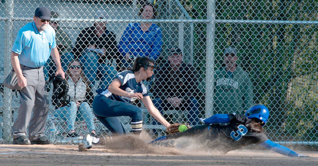 Photo by Paul Lien                                Ari Marshall (3) slides under the tag to score a run for South Whidbey.
