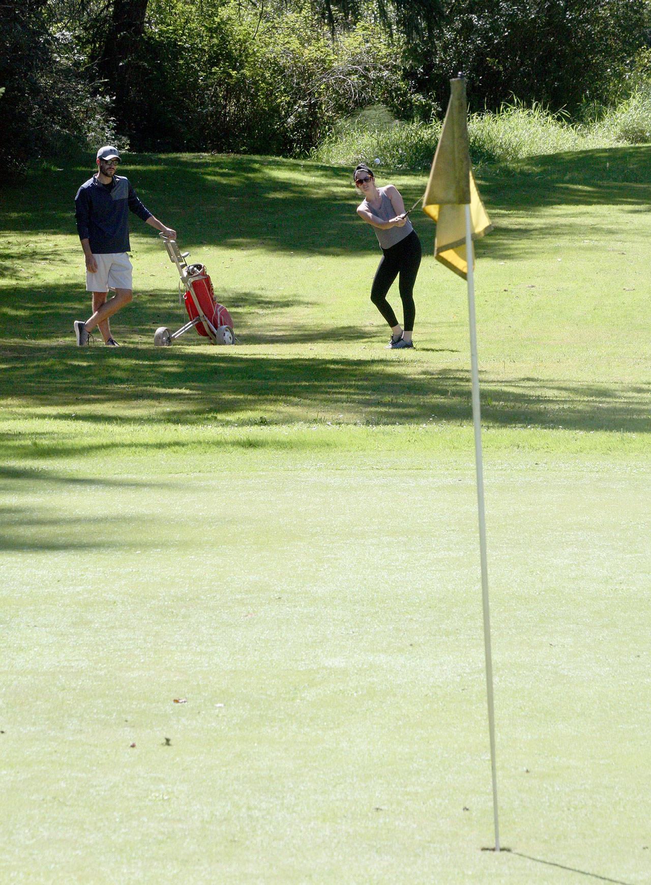 Stephanie Winship hits an approach shot at the Island Greens, which will close Sunday.(Photo by Jim Waller/Whidbey News-Times)
